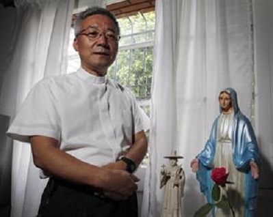Han Lim Moon posa delante de una estatua de la Virgen y otra de san Andrés Kim, primer sacerdote coreano. FOTO NACION-Emiliano Lasalvia