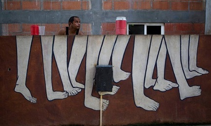 Un salvadoreño se ocupa de la ropa en una lavandería pública en el pueblo de Tenosique, México, donde se refugió con su familia. (Foto Rebecca Blackwell AP)