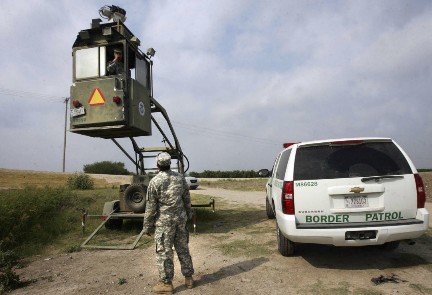 Un miembro de la Guardia Nacional observa a un compatriota de la Patrulla Fronteriza en un Skybox (Foto AP)